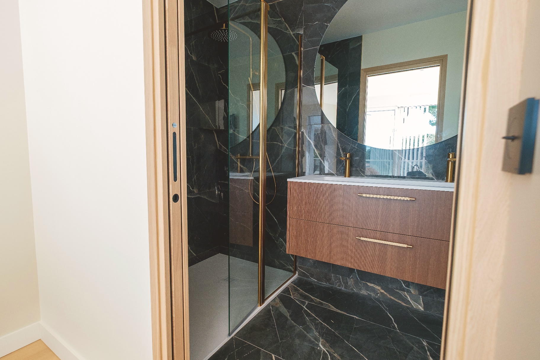 Salle de bain en marbre noir avec douche à l'italienne