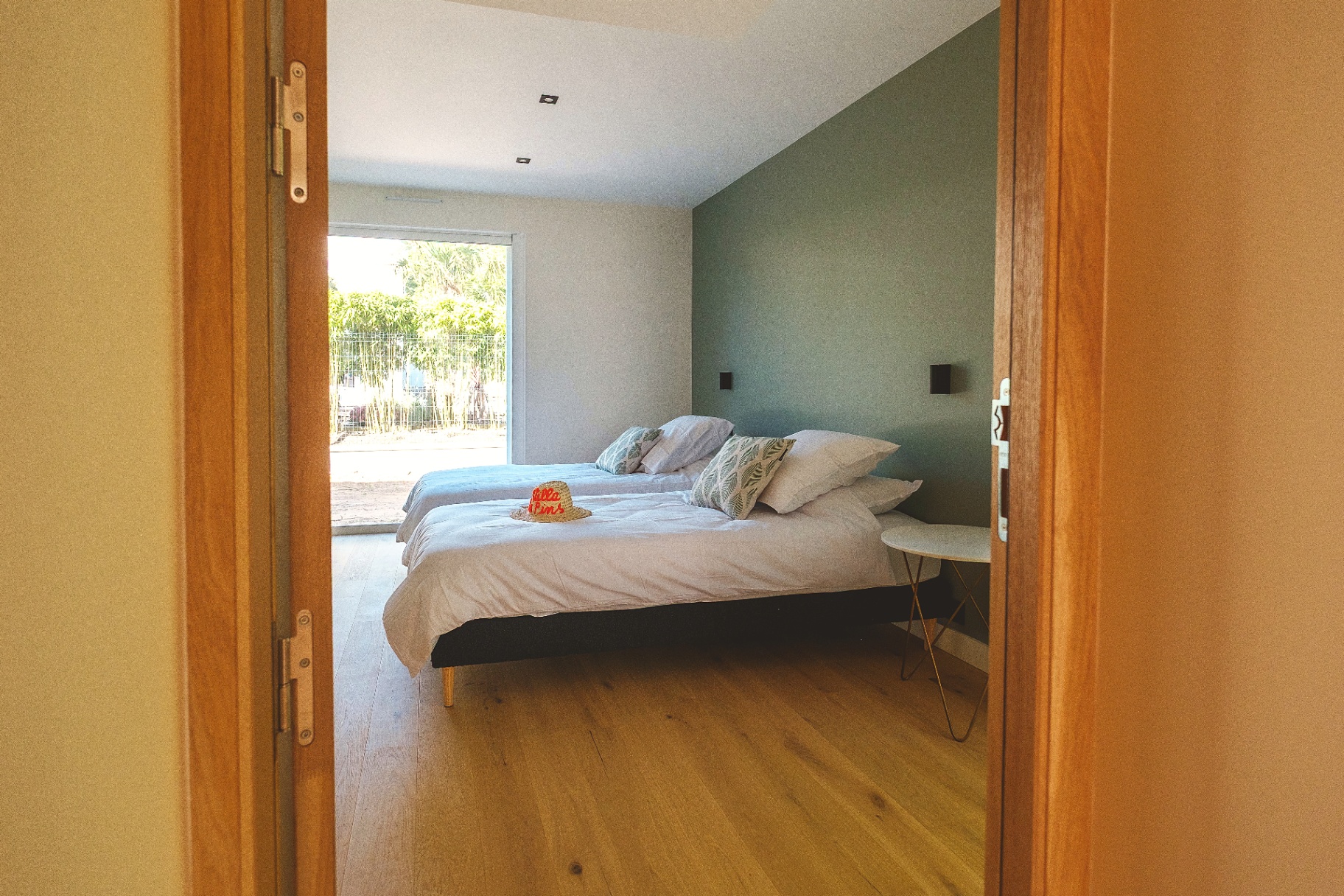 Chambre avec lits jumeaux et mur vert d'eau